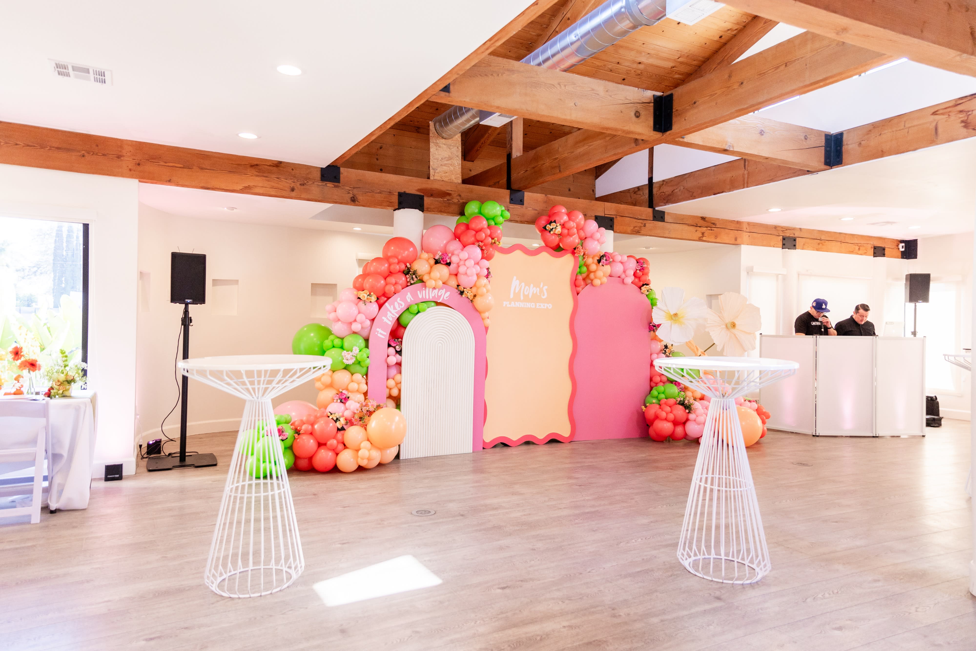A bounce house and a balloon arrangement in a decorated space for a baby shower.
