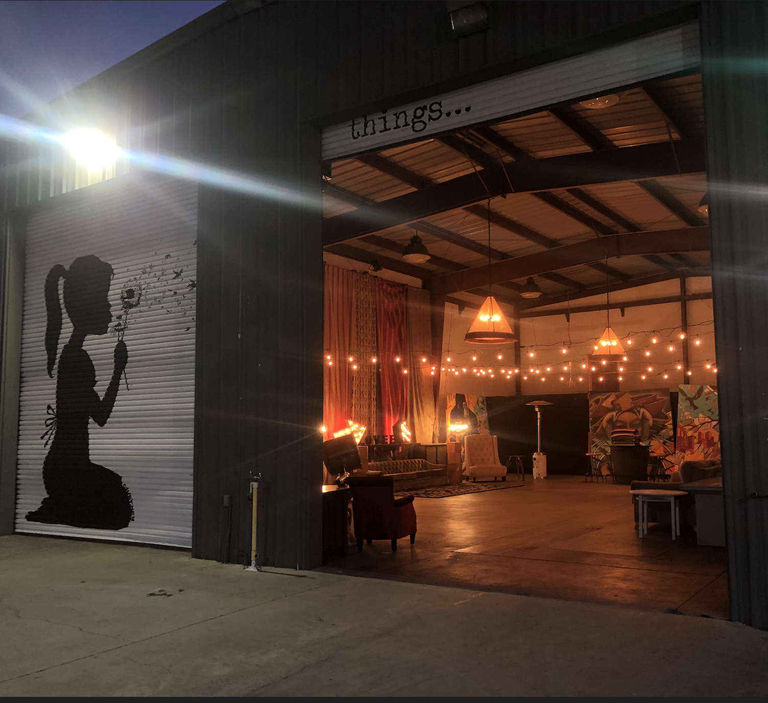 The venue is set up for a 50th birthday party, featuring decorative lighting, a large '50' display, and a dance area illuminated by colorful spotlights.