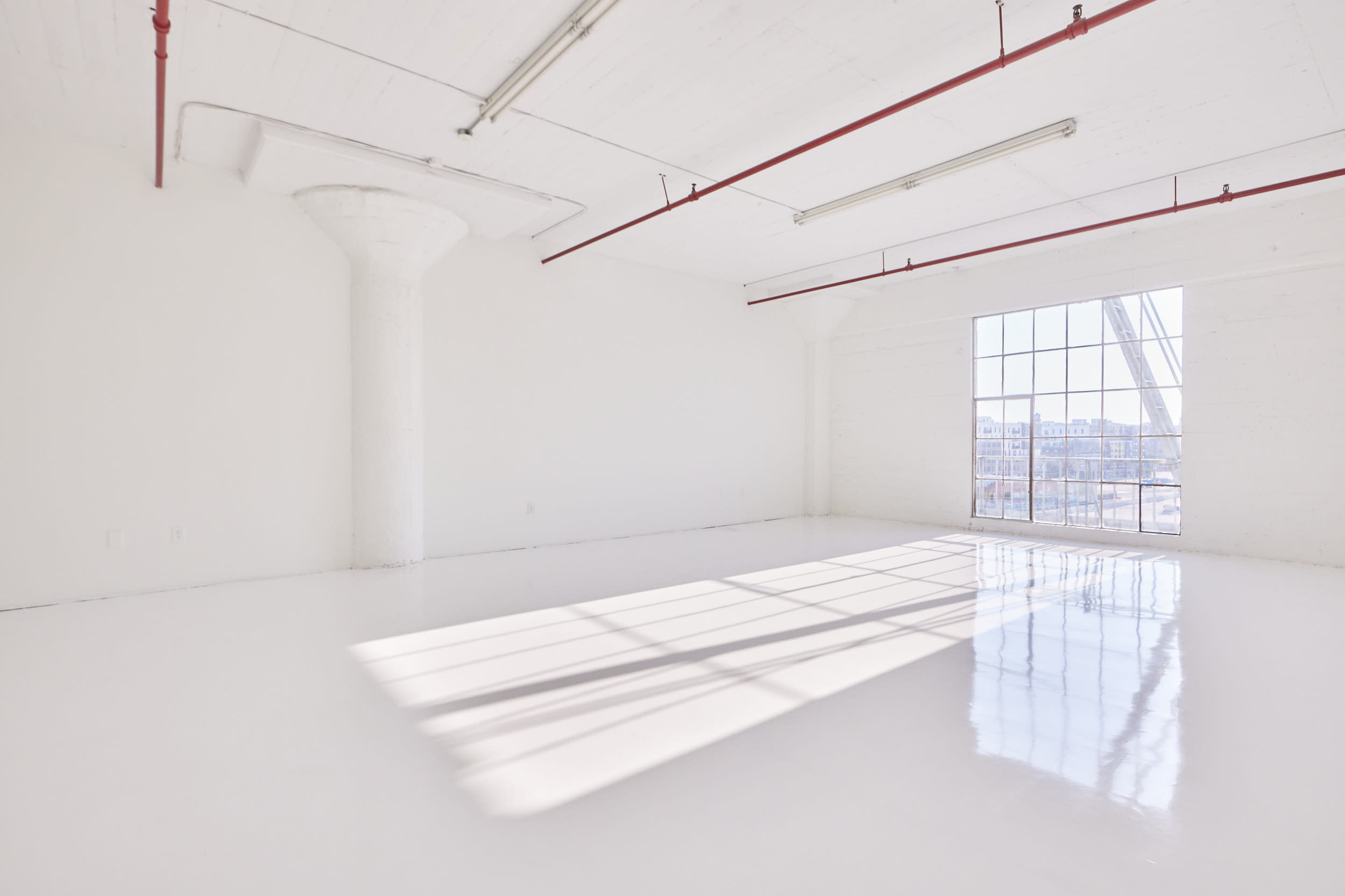 A ladder leans against a large window, framing a view of the city skyline beyond.