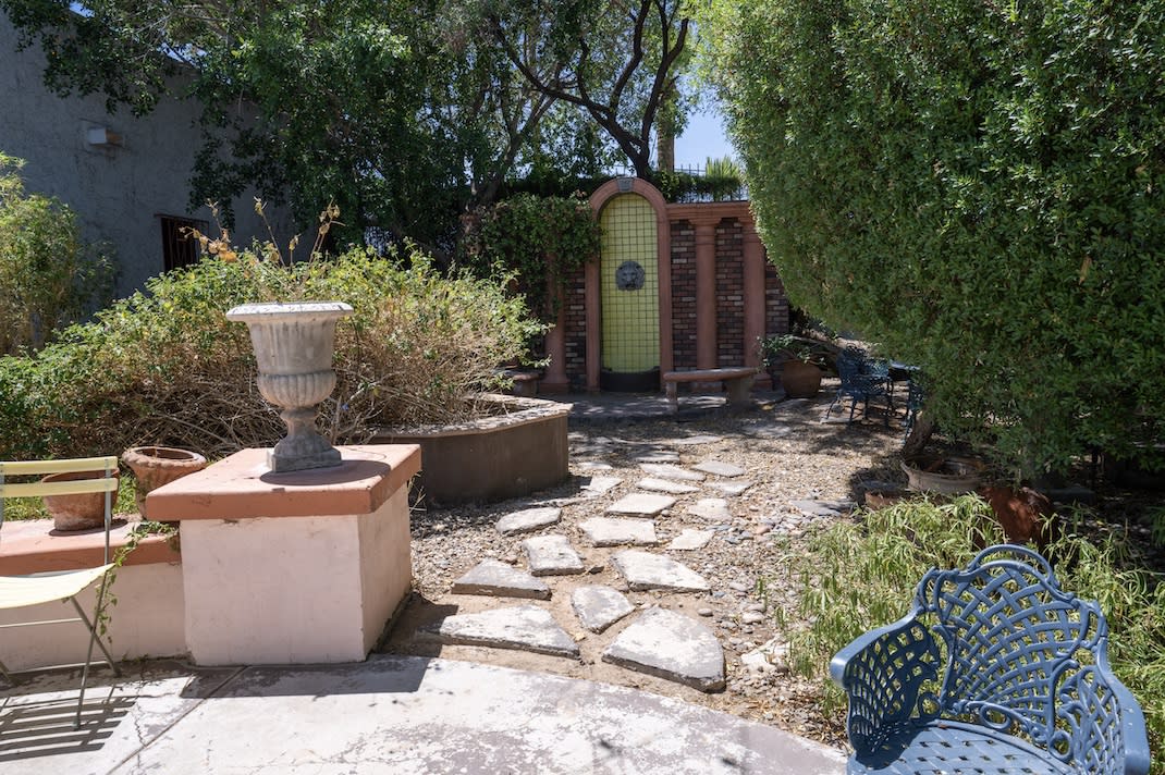 A beautifully arranged outdoor area features a framed sign asking, "Genesis, will you marry me?" with candles lining a pathway.