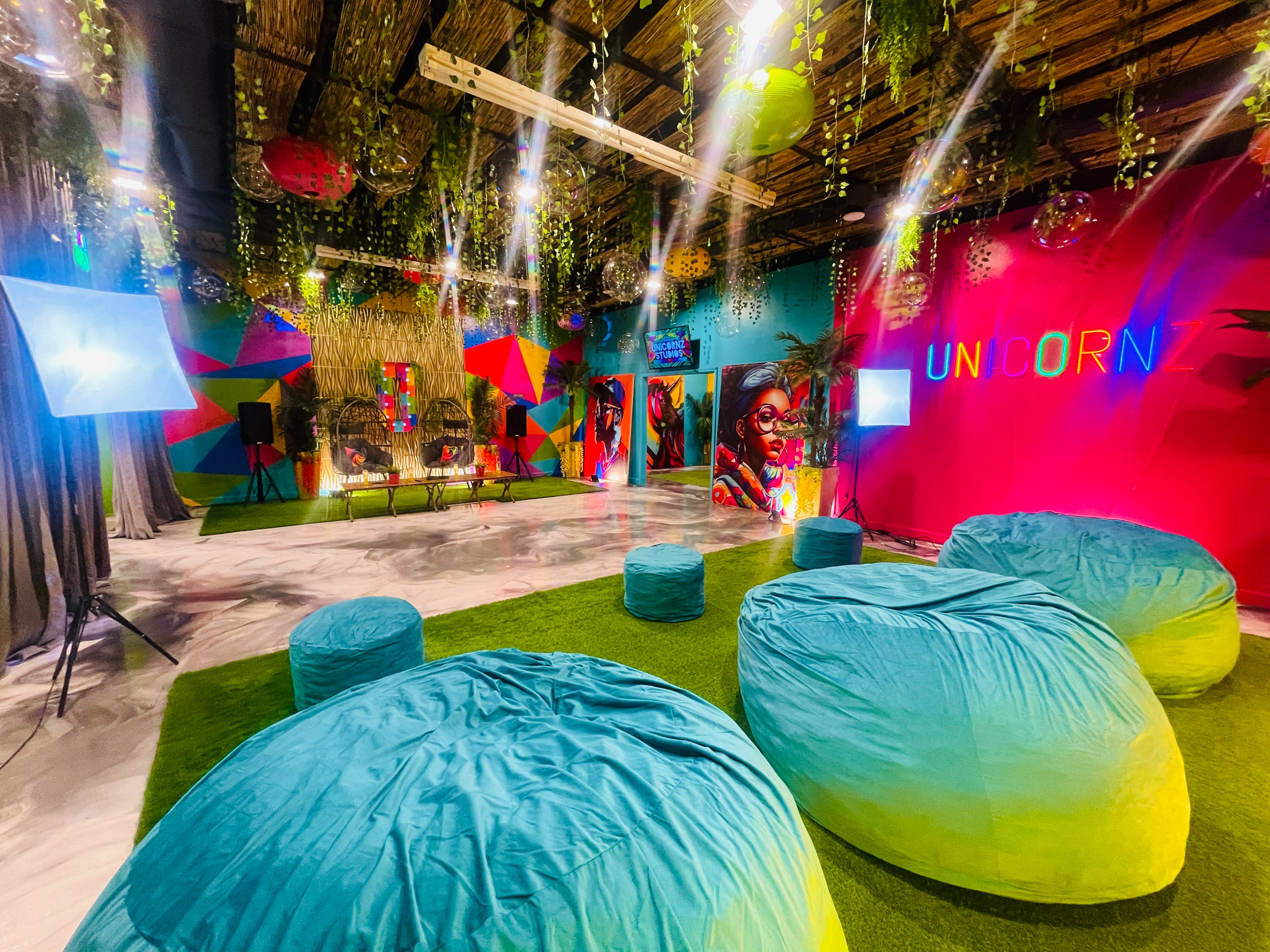 A group of friends gathers at a colorful venue to celebrate a birthday party, enjoying conversation and food amidst festive decorations.