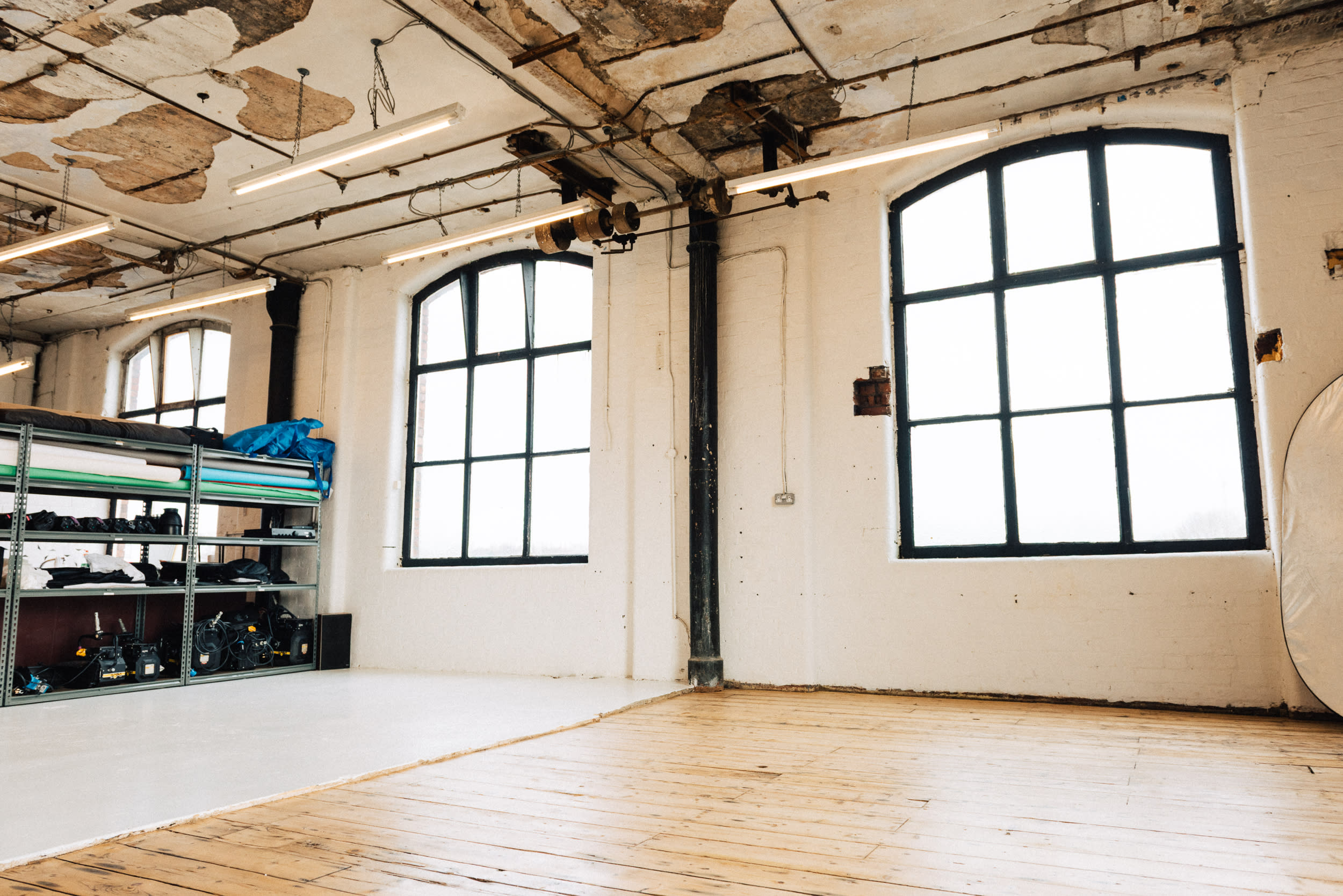 A sparse room with large windows features a microphone and musical equipment arranged for a music video shoot.