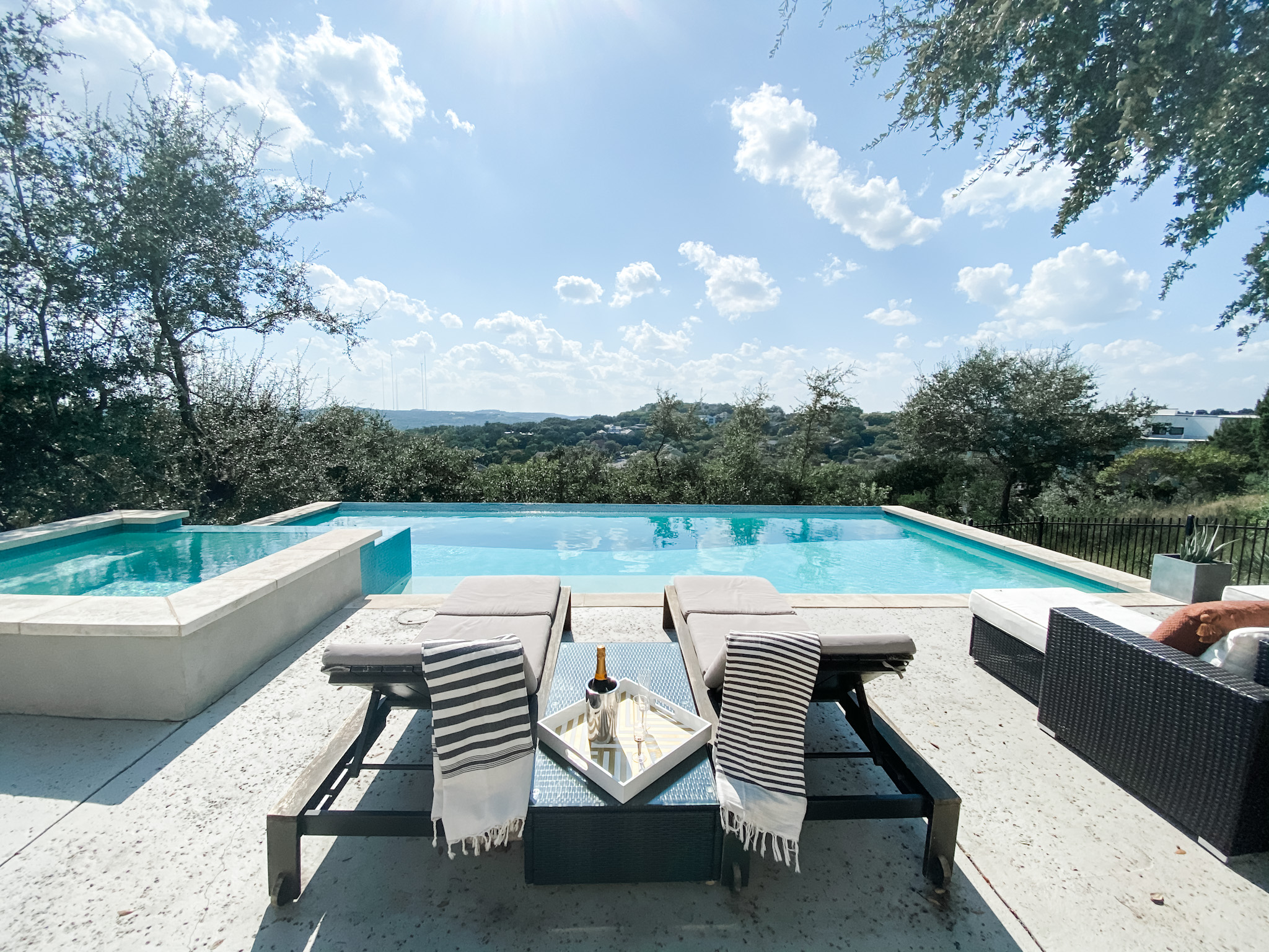 A vibrant 30th birthday celebration takes place by an infinity pool overlooking a scenic landscape under a clear blue sky.
