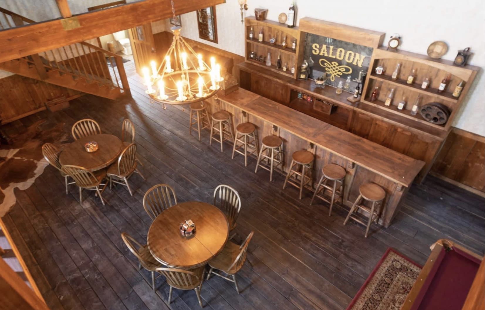 A video shoot is taking place in a rustic interior featuring wooden furniture and western-themed decor.