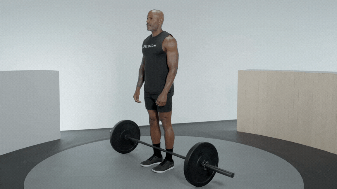 Peloton instructor Adrian Williams demonstrating a sumo deadlift with a barbell.