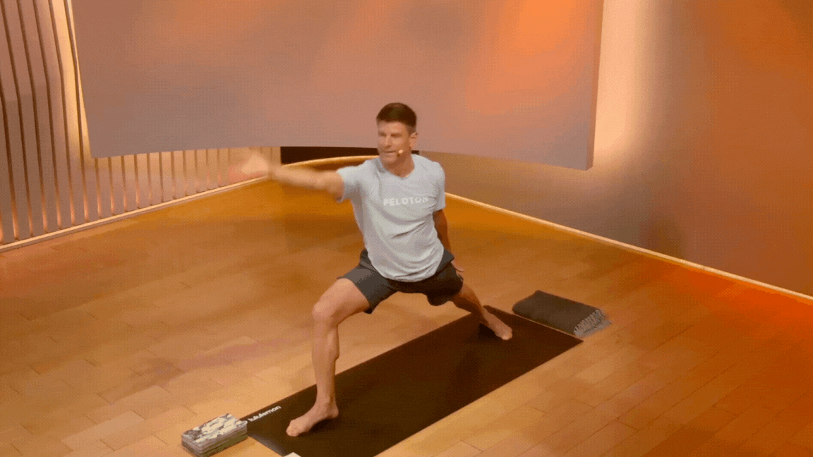 Peloton instructor Denis Morton moves through Peaceful Warrior pose and Extended Side Angle pose during a Peloton yoga class.