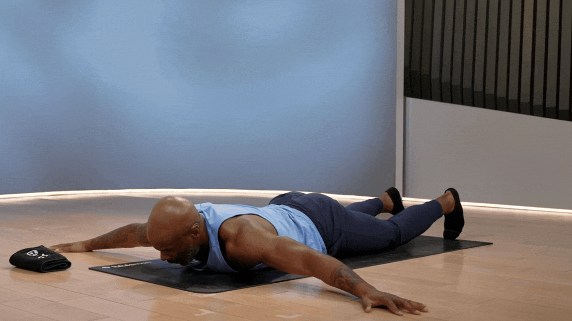 Peloton instructor Adrian Williams demonstrates the scorpion stretch during a Peloton stretch class.