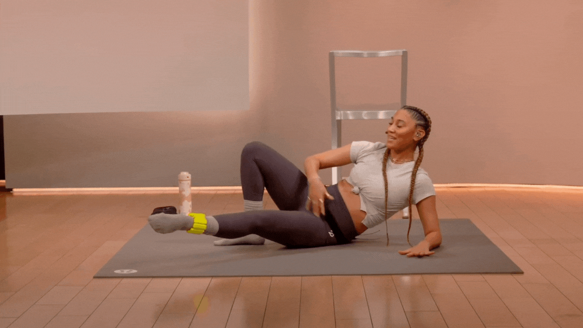 Peloton instructor Ally Love demonstrates an adductor leg lift with ankle weights during a Peloton barre class