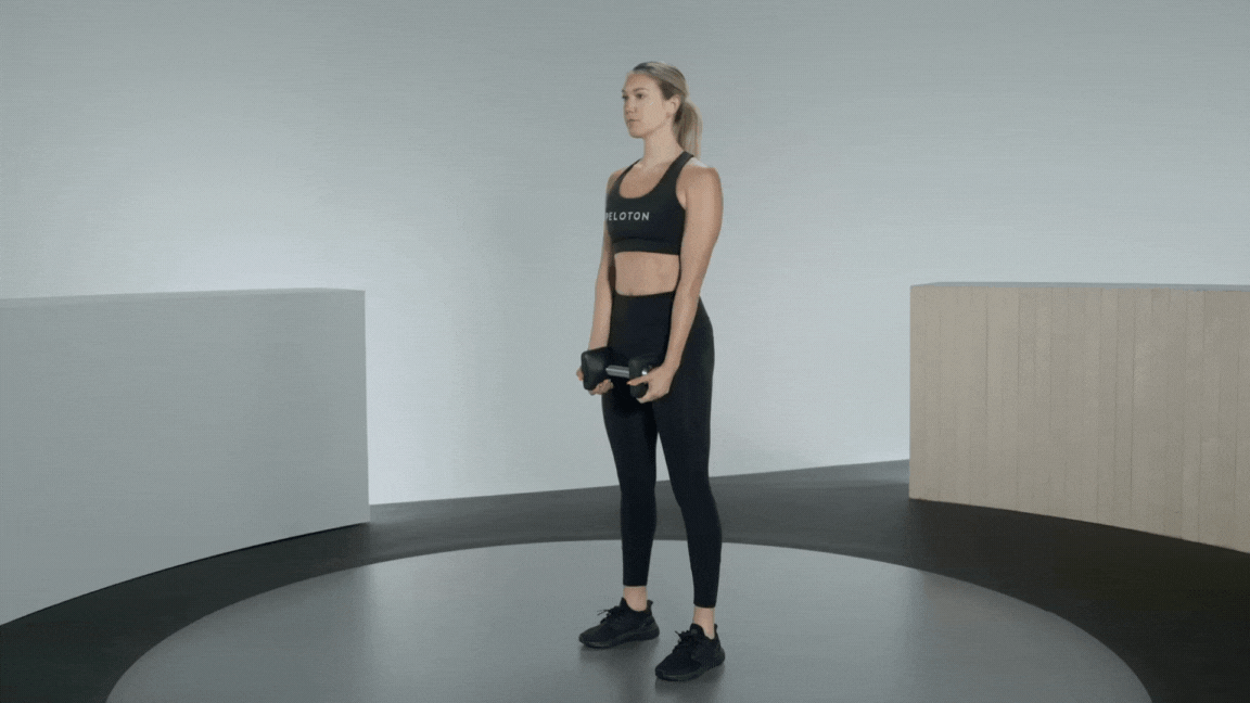 Peloton instructor Callie Gullickson demonstrates a dumbbell good morning standing core exercise with proper form