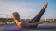 Woman practices Pilates Hundred exercise
