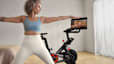 Woman doing a yoga cross training workout at home with her Peloton Bike.