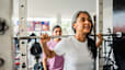 Woman squatting a barbell to build strength while exercising during menopause.
