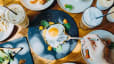 Birds-eye view of someone eating a sunny-side-up egg (a complete protein) at an outdoor restaurant.