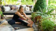 Woman sitting on a yoga mat stretches hamstring 