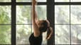 Woman practices Sun Salutations during a yoga flow