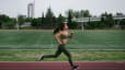 Woman runs outside on a track, how to increase vo2 max