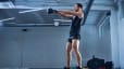 Man doing a kettlebell swing inside
