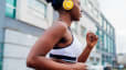 A woman jogging with headphones on outside. Jogging can be a form of mindful movement.