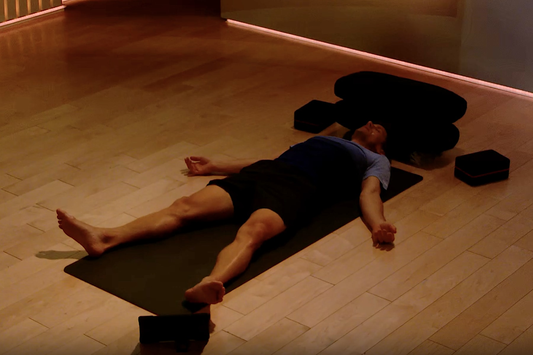 Denis Morton meditating and practicing savasana while lying down.