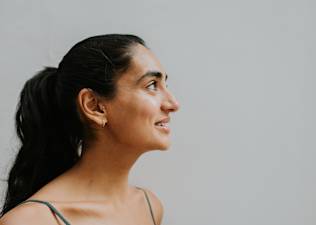 A side profile of a young woman smiling and looking up.