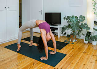 Woman does Wheel Pose, a yoga backbend, during an at-home yoga practice