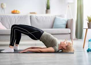 Woman practices a Bridge yoga pose