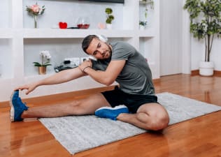 Man stretches at home