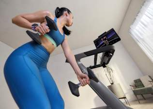 Woman training with Peloton wearing an integrated wearable