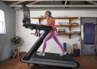 Woman runs on Peloton Tread+ at home