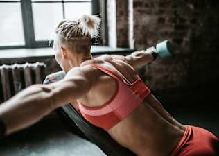 Woman doing an chest supported reverse fly as a rear deltoid exercise.