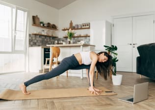 Woman practices Pilates class at home 