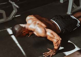 Man doing bodyweight back exercises in a gym.