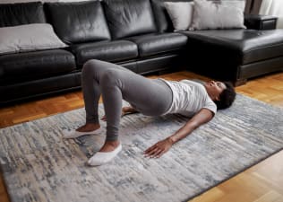 Woman at home practices glute bridge exercise 