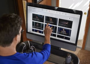 Man looks at classes to take on the Peloton Tread