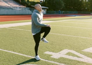 Man doing high knees on football field