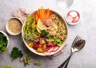 A colorful buddha bowl with non-meat protein sources like quinoa, edamame, and hummus, among other veggies.