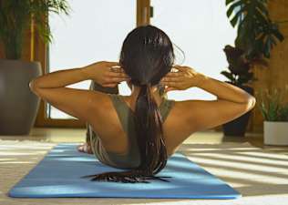 Back view of a woman doing a sit-up.