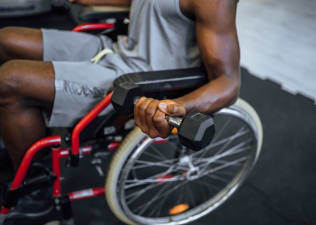 man doing biceps curls in wheelchair