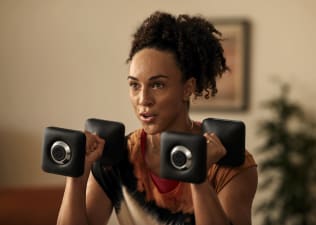 Woman holds two dumbbells 