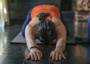 Woman practices Child's Pose, yoga for runners