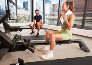Two exercisers sitting on Peloton Rows after workout