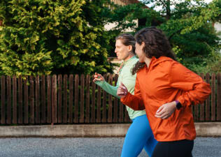 Two women jog together, practicing zone 2 cardio