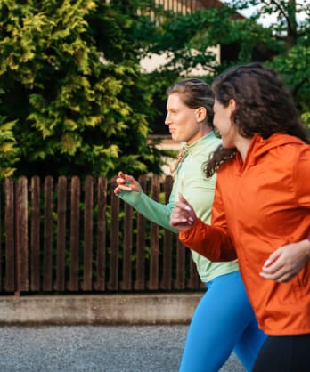 Two women jog together, practicing zone 2 cardio