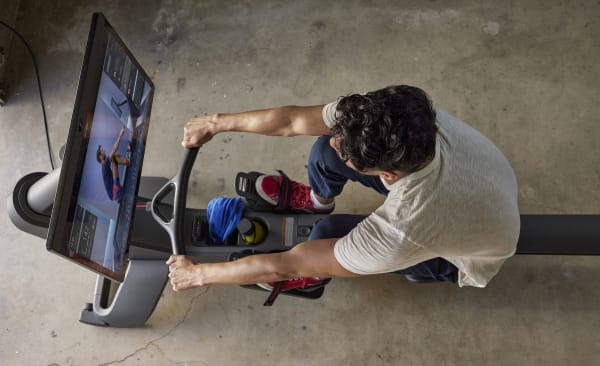 Man looks at his strokes per minute on a rowing machine