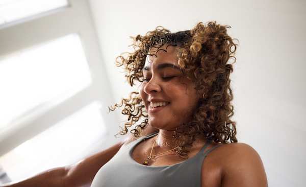 A close-up photo of a happy woman feeling confident during a workout.