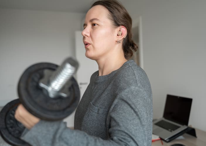 Woman does a bicep curl exercise with dumbbell