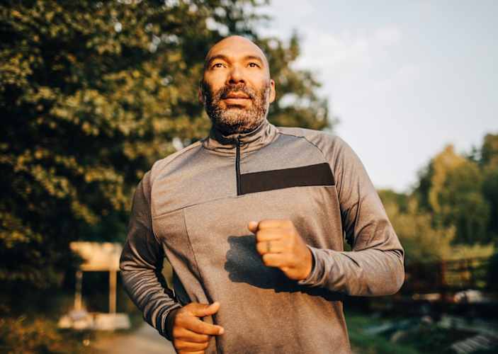 A middle-aged man going for a run outside in the morning.