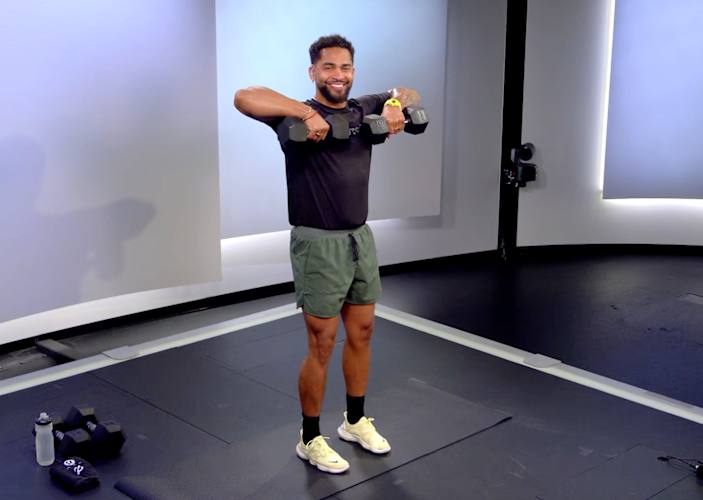 Peloton instructor Rad Lopez demonstrating a dumbbell upright row with proper form