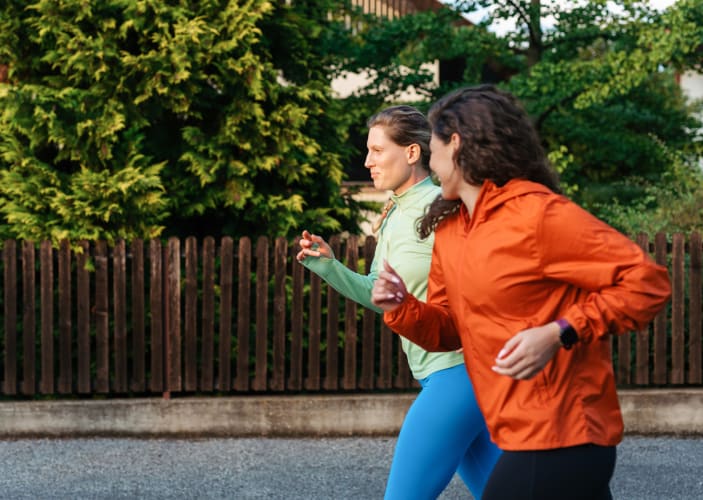 Two women jog together, practicing zone 2 cardio