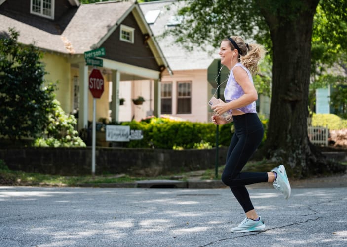 Woman running outside with headphones